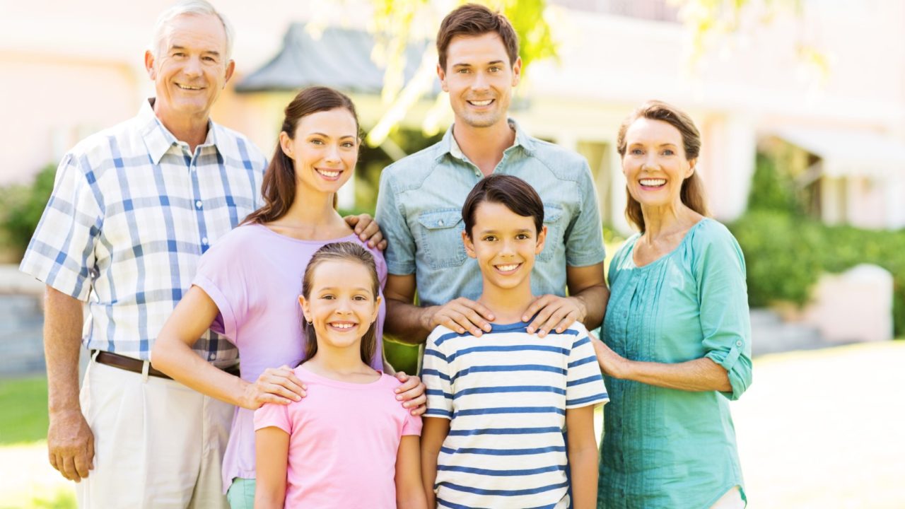 Smiling Multi-Generation Family In Front Garden